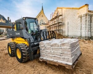 Compact construction equipment using a pallet fork attachment on jobsite